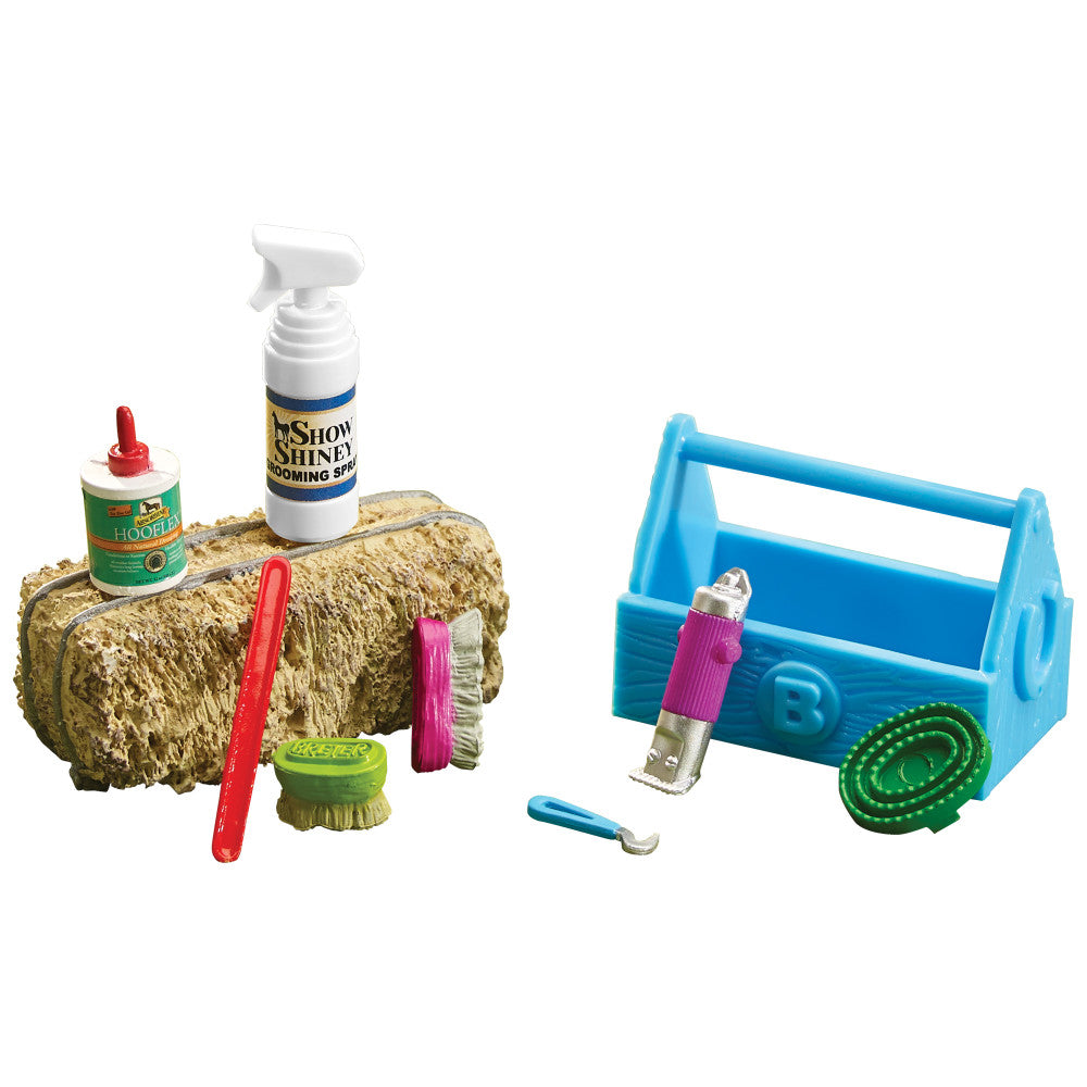 Horse grooming kit with straw-textured practice log, spray bottle labeled Show Shine, hoof pick, brushes, blue toolbox caddy, and green grooming tool