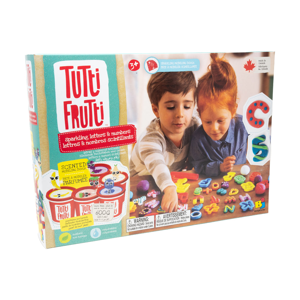 Tutti Frutti Sparkling Letters & Numbers modeling dough set package showing two children playing with colorful scented dough letters and numbers on a table