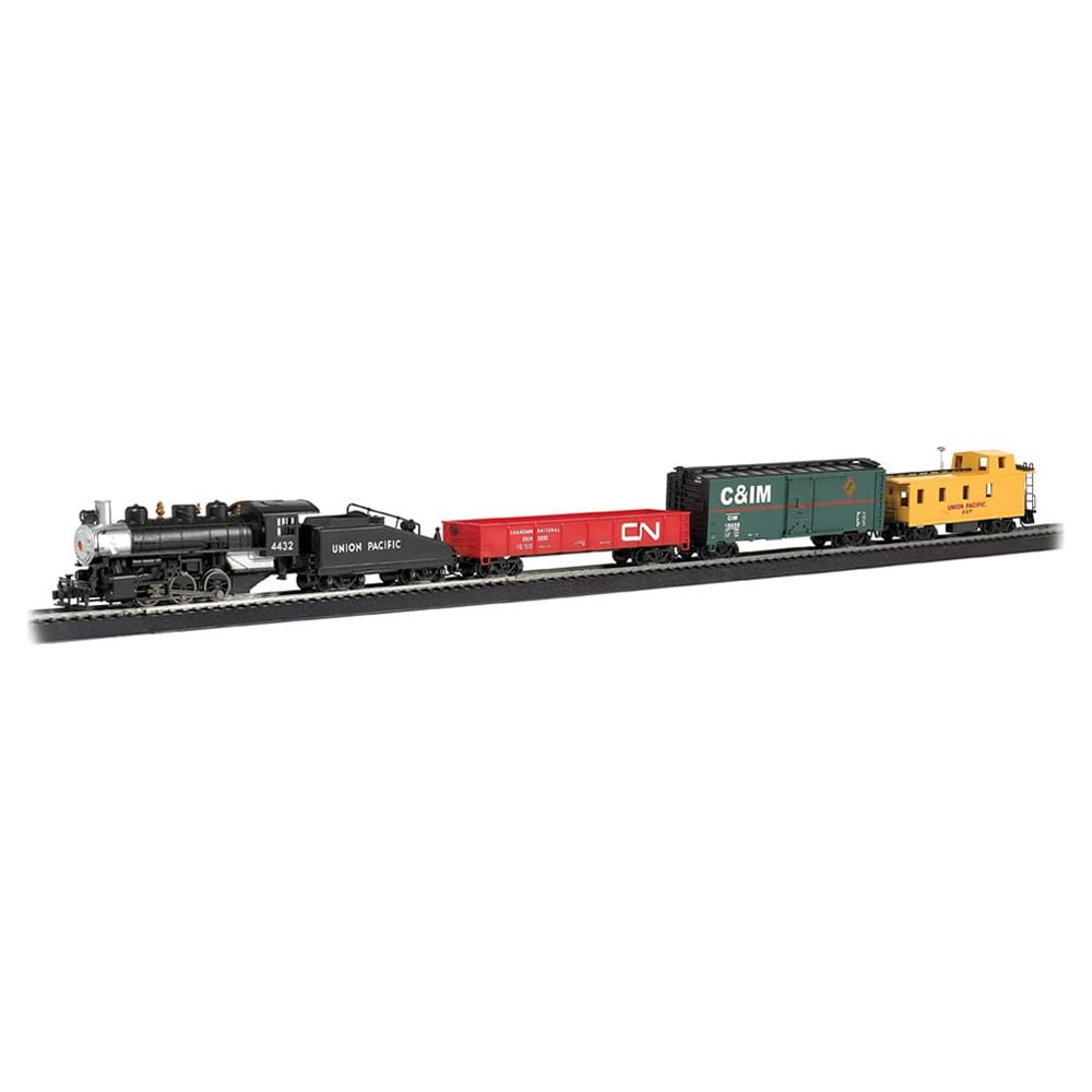 Pacific Flyer HO scale train set with black steam locomotive, Union Pacific tender, red CN freight car, and yellow caboose on black track