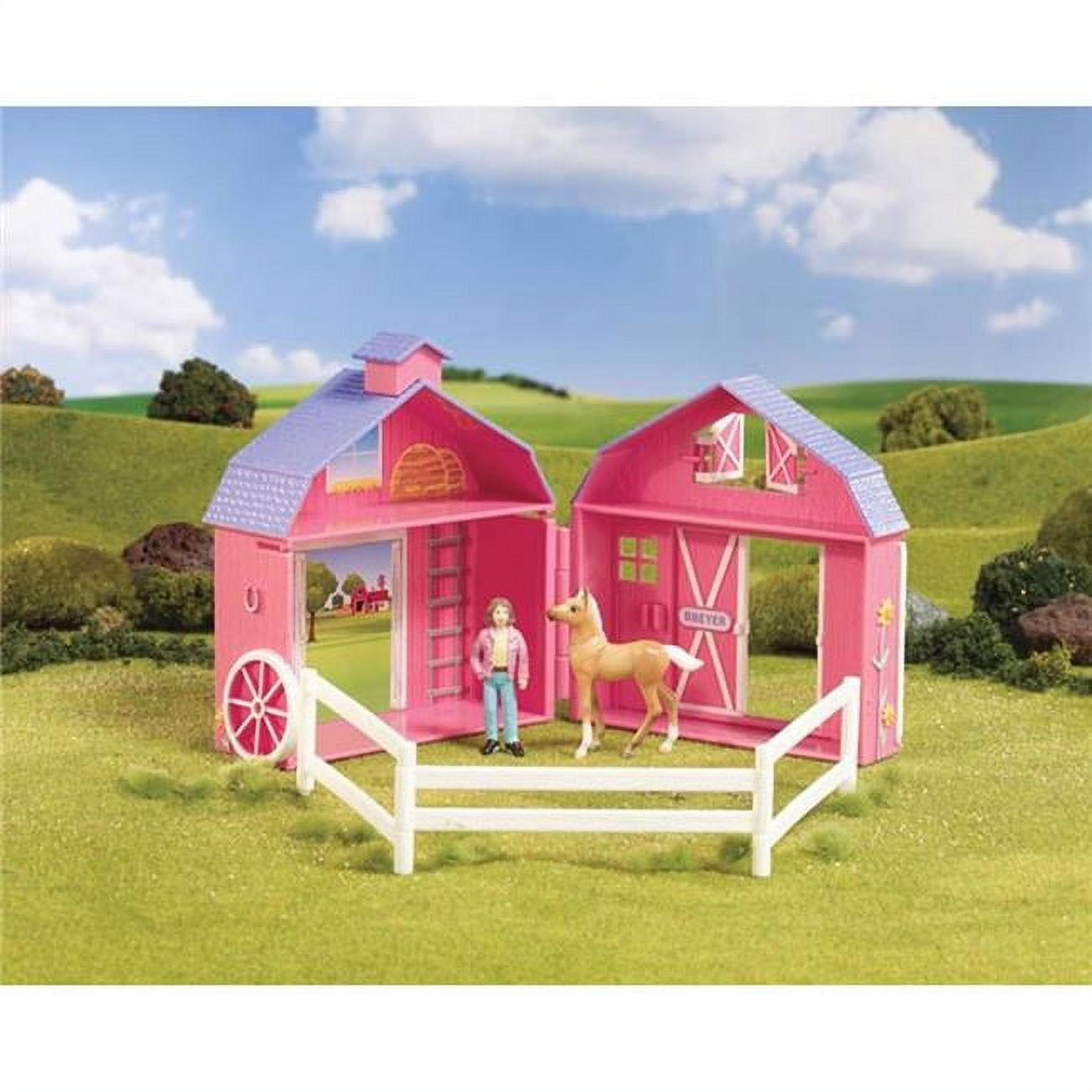Pink barn playset with white fence, featuring a doll figure and tan horse in a pastoral landscape setting