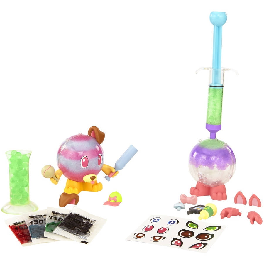 Orbeez Crushkins Pets playset showing two colorful bead-filled character figures with accessories including a blue syringe applicator, beads in packets, small r