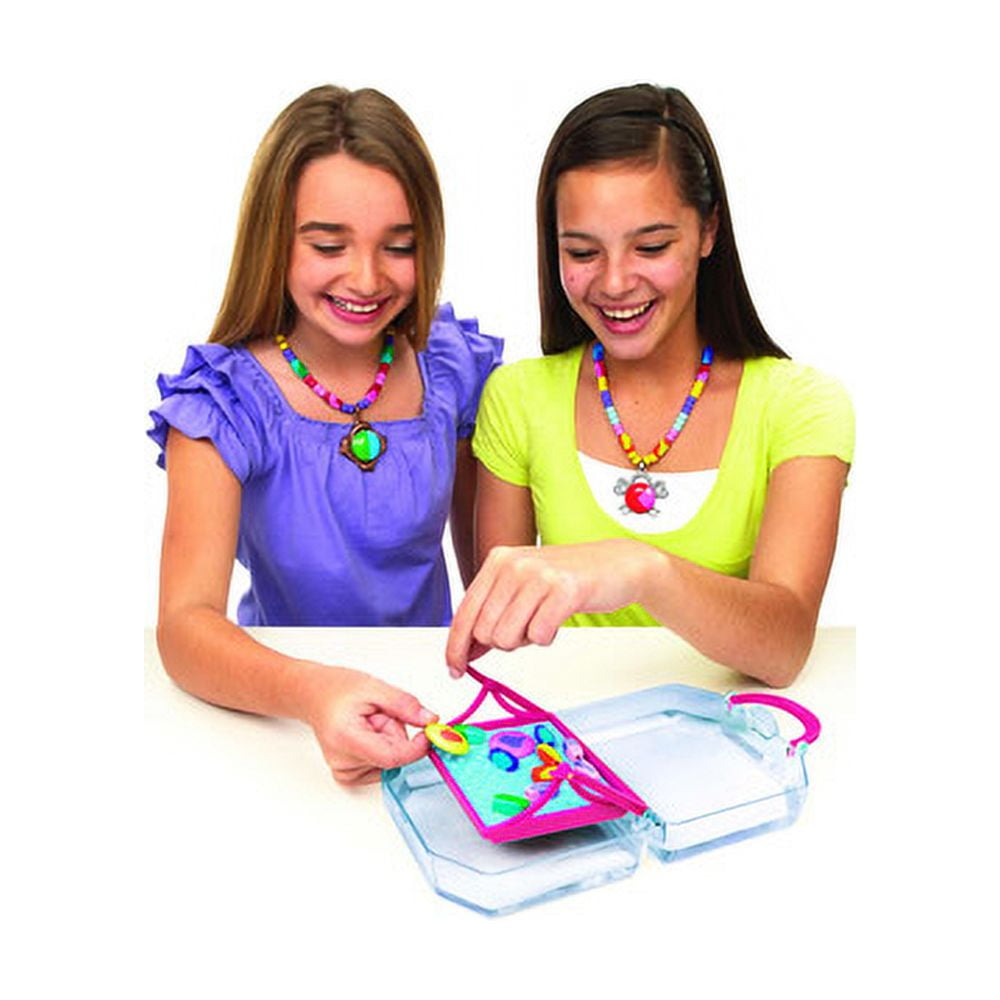 Two children modeled by girls playing with Color Splasherz fashion purse craft set, holding pink purse with colorful beads over clear storage container