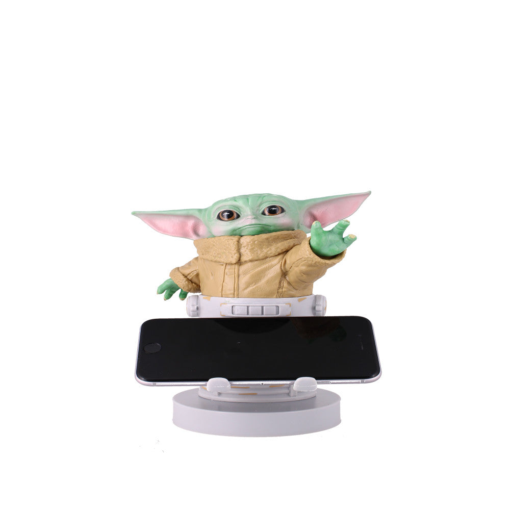 The Child character figure in tan robes on circular stand holding smartphone, with one hand raised