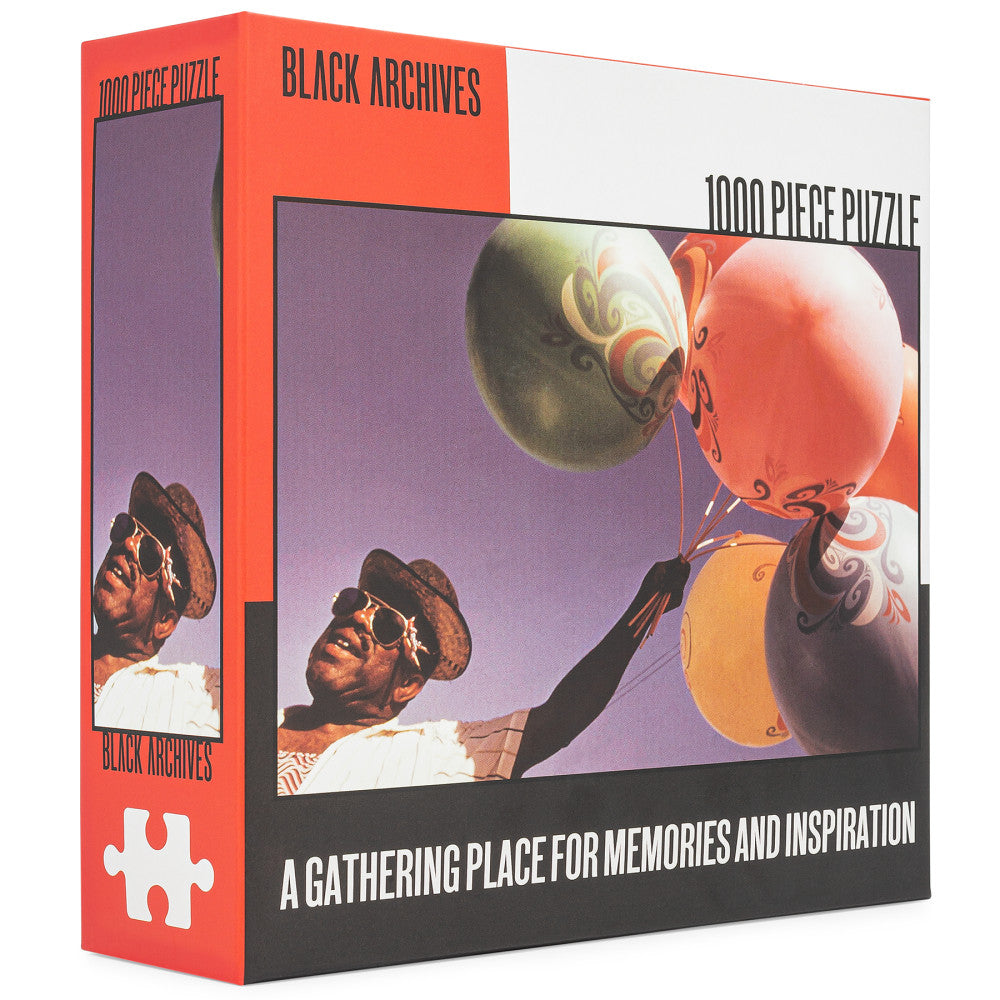 Black Archives 1000 piece puzzle box featuring vintage-style illustration of man with sunglasses holding decorative balloons against purple sky