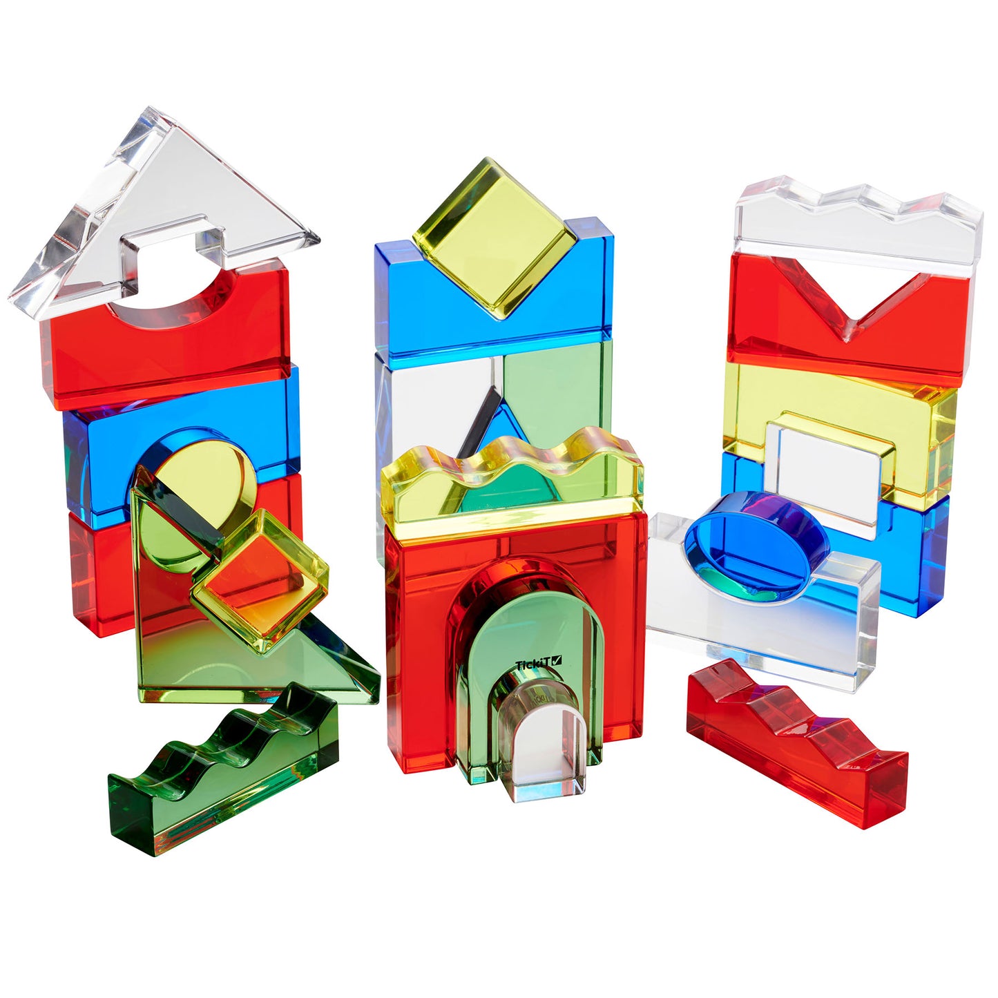 TickiT Color Crystal Block Set with 25 transparent and translucent acrylic pieces in red, blue, yellow, green, and clear, arranged to show various geometric sha