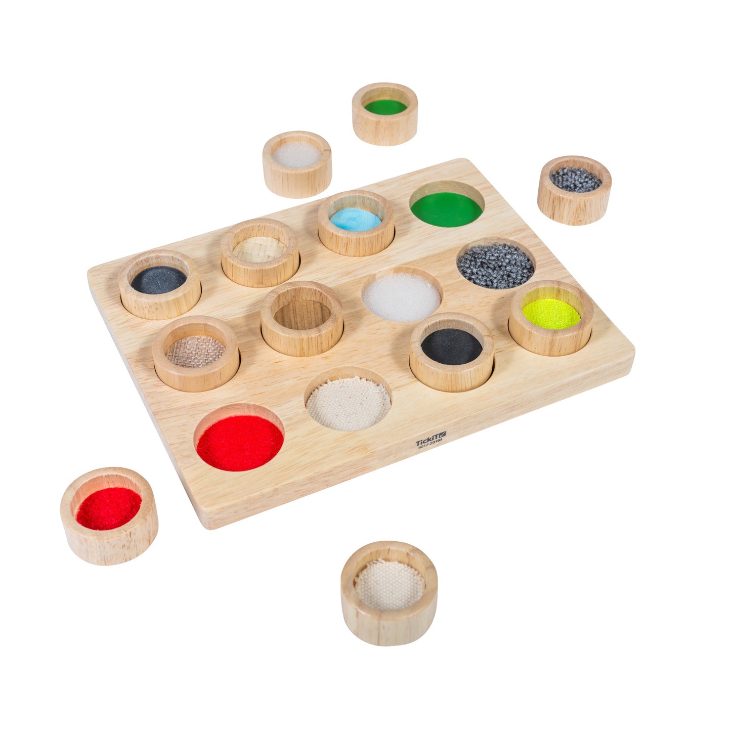 Wooden touch and match board with 16 removable lidded cups containing different textured materials in various colors including red felt, blue beads, green gel,