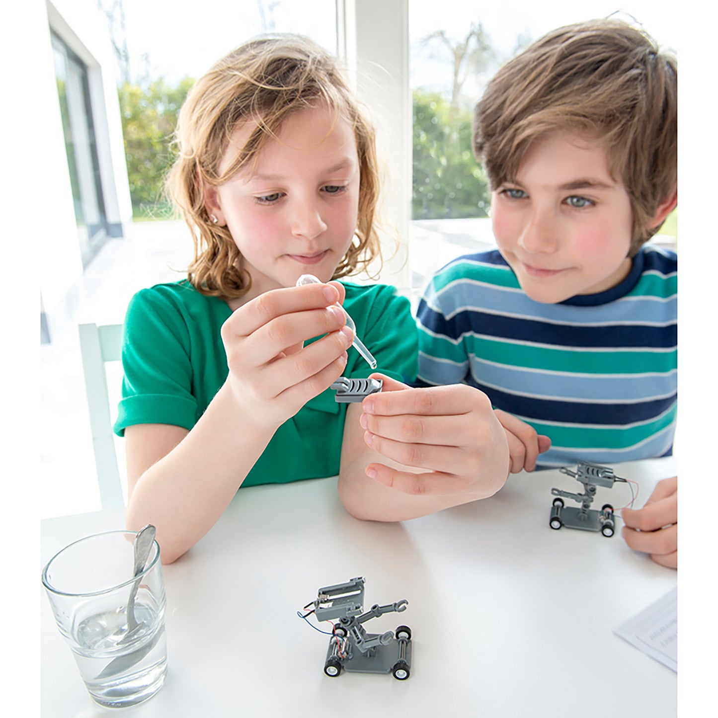 Green Science Salt-Powered Robot toy with kids assembling metal robot components