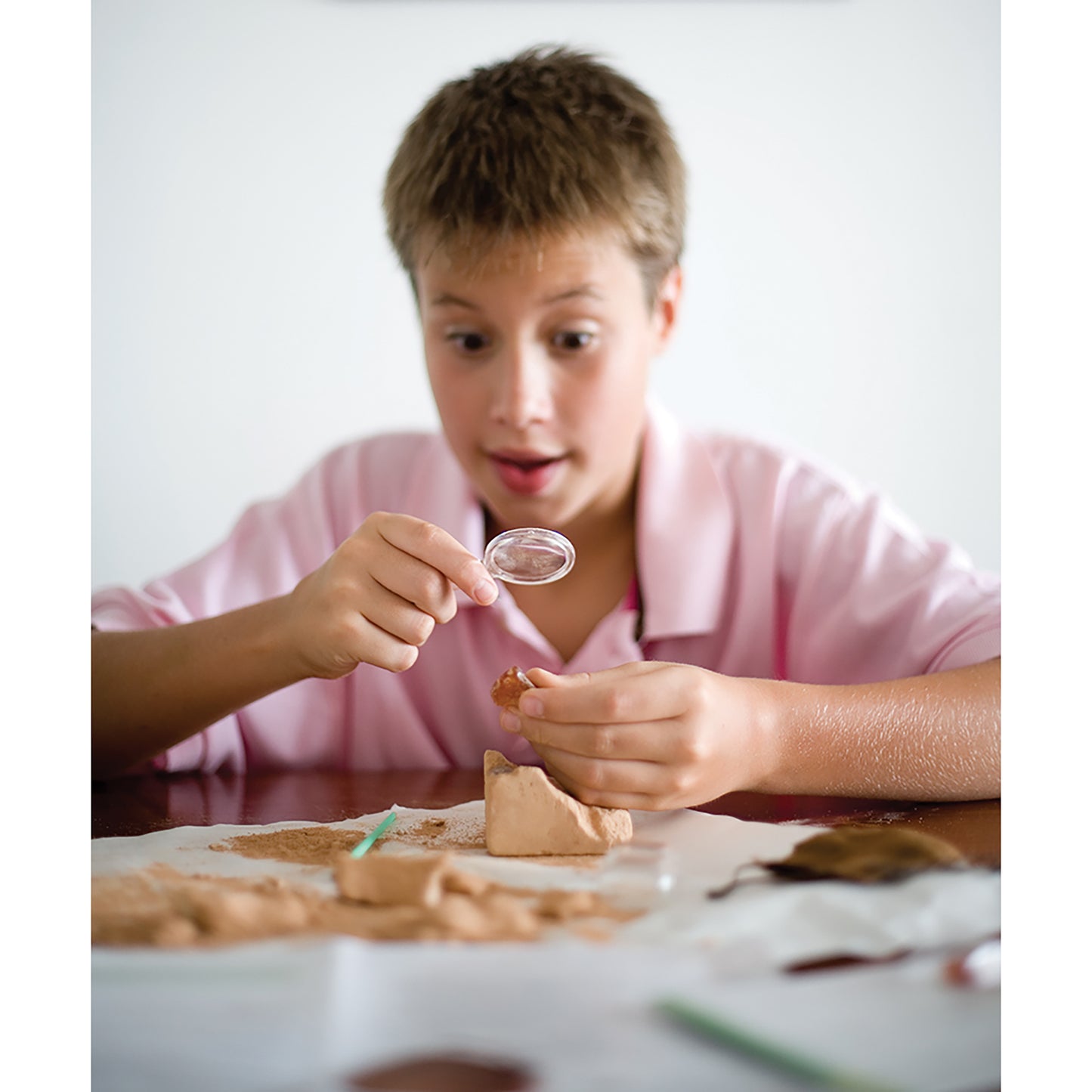4M KidzLabs Crystal Mining Kit - boy excavating crystals from plaster block with tools