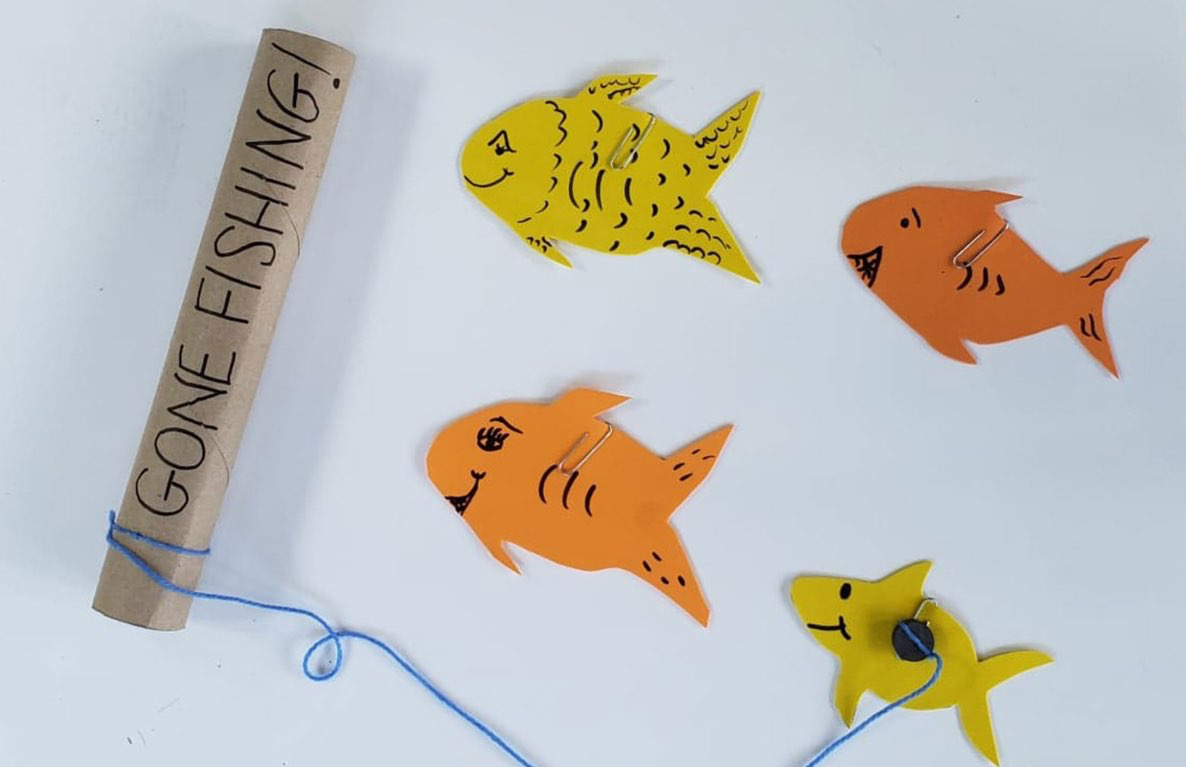 DIY Gone Fishin' game with cardboard fishing rod labeled "GONE FISHING" and blue string, four colorful paper fish cutouts in yellow and orange with drawn-on det