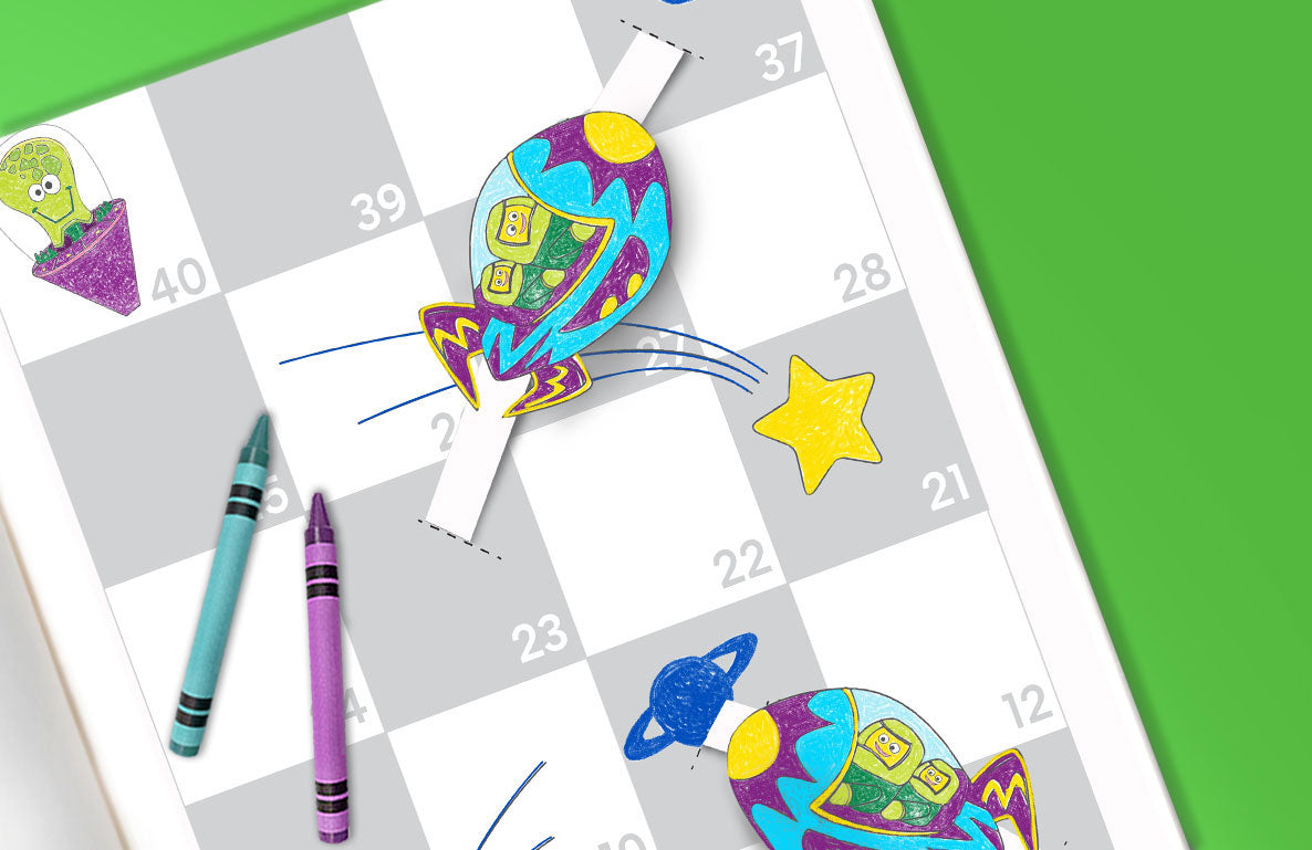 Colorful space-themed board game with numbered squares, rocket and planet game pieces, yellow star, and teal and purple crayons on green background