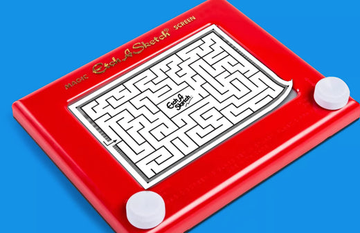 Red Etch A Sketch toy with maze puzzle displayed on screen, white control knobs on blue background