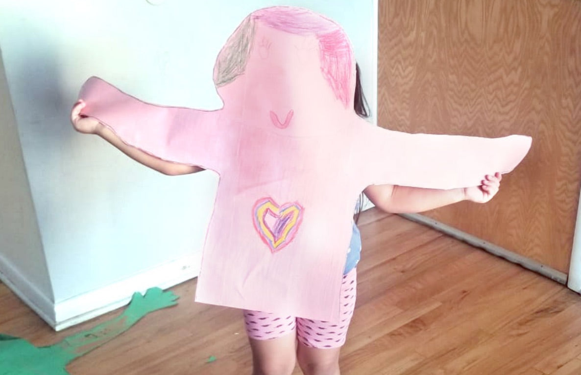 Child wearing pink shirt with heart design and patterned leggings, arms outstretched in hugging pose