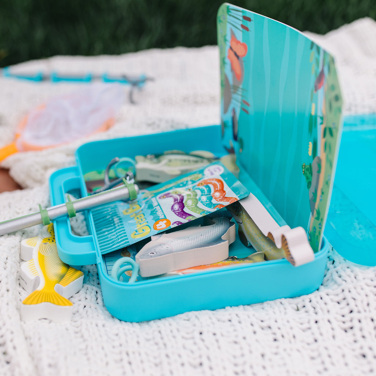 Melissa & Doug Let's Explore Fishing Play Set with turquoise case, fishing rod, and colorful fish toys