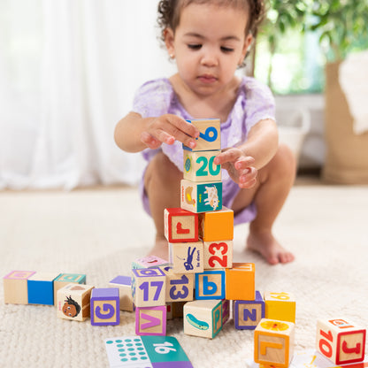 Melissa & Doug Ms. Rachel Wooden Learning Blocks Set with colorful numbered and lettered blocks being stacked by a to...