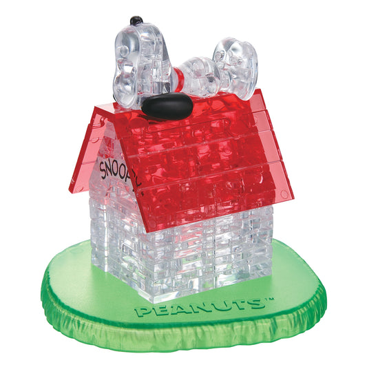 BePuzzled Peanuts Snoopy House 3D Crystal Puzzle with red roof, clear brick walls, and transparent Snoopy figure on top, mounted on green grass base
