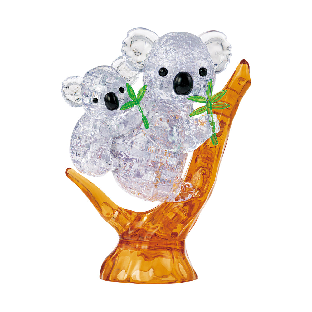 Two clear plastic koala figures with black eyes and green leaves on an orange branch, 3D crystal puzzle assembly