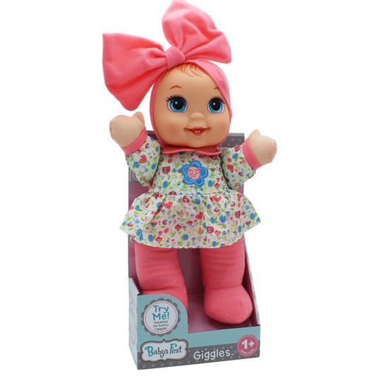 Baby's First Giggles doll with pink bow, blue eyes, floral print dress, and pink legs in packaging