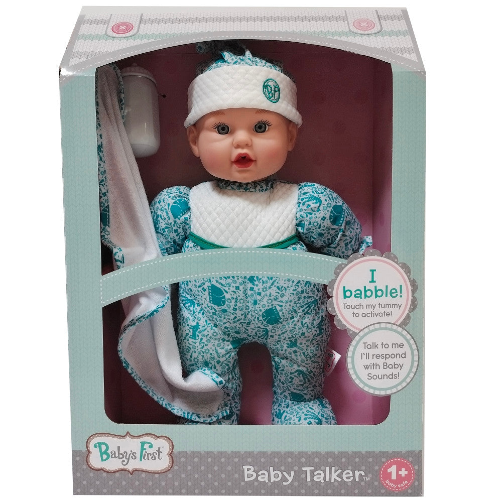 Baby's First Baby Talker interactive doll in packaging, wearing white headband and teal patterned outfit with white bib, includes bottle and blanket accessories