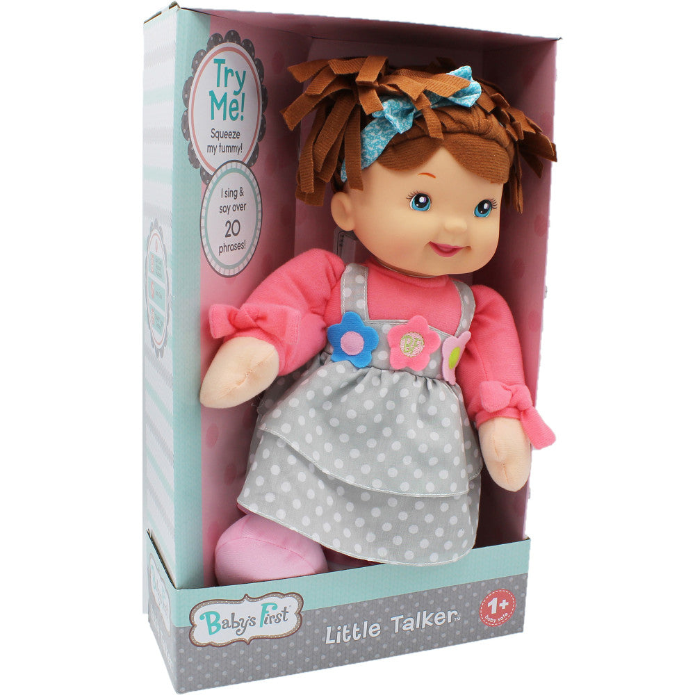 Baby's First Little Talker doll with brown hair, blue bow, pink long-sleeve shirt, and gray polka-dot dress in packaging