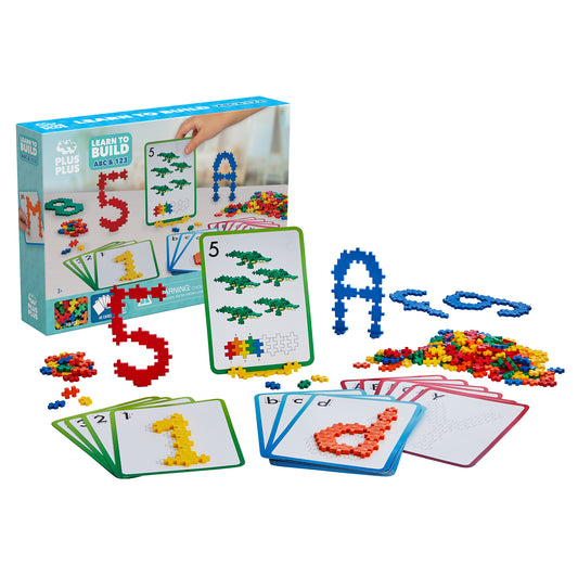 Plus-Plus Learn to Build Set with colorful plastic building blocks, instruction cards showing numbers and letters, and assembled block shapes including the numb