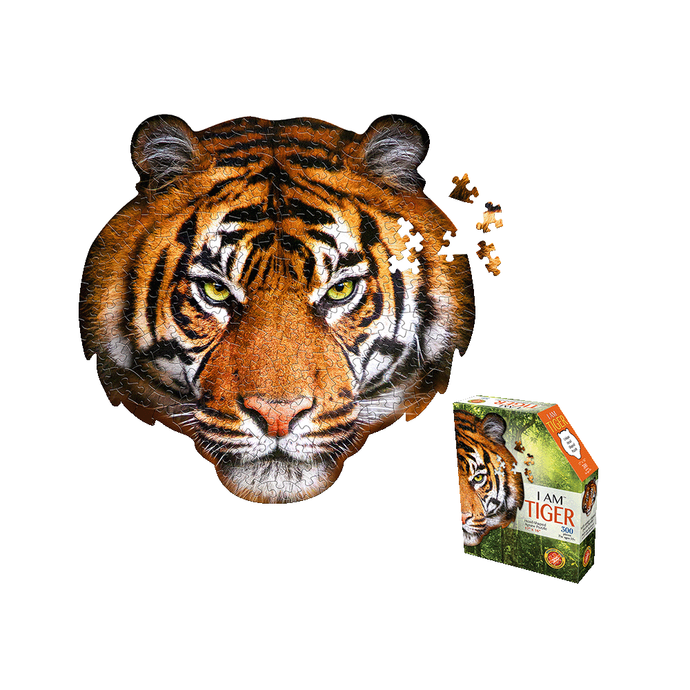 Tiger face-shaped jigsaw puzzle with yellow eyes and black stripes on orange, shown assembled with loose pieces, next to product box labeled 'I AM TIGER 300 pc'