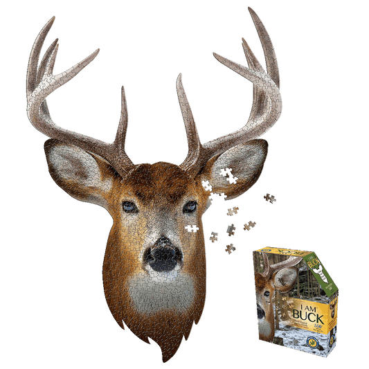 I AM BUCK jigsaw puzzle showing deer head-shaped puzzle with brown fur, large antlers, and scattered puzzle pieces, next to yellow and green product box