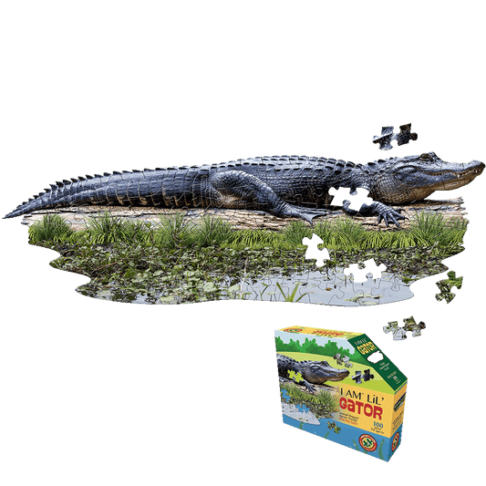 Madd Capp I AM LiL' Gator 100-piece jigsaw puzzle shown completed as an alligator-shaped puzzle on wetland background, with product box displayed below