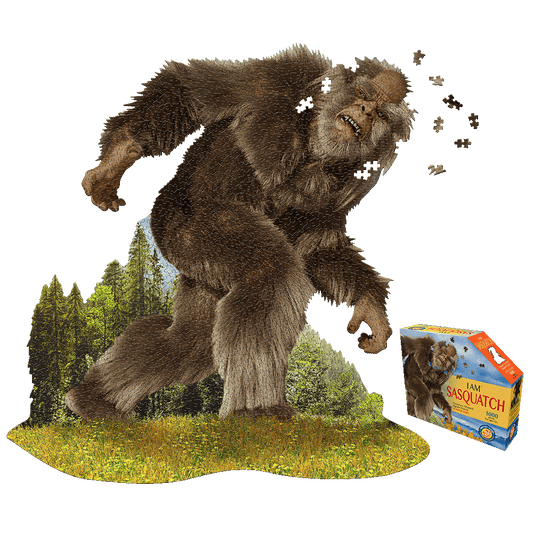 Madd Capp Sasquatch Shaped Jigsaw Puzzle box and completed puzzle showing a large brown Sasquatch in a forest landscape with scattered puzzle pieces