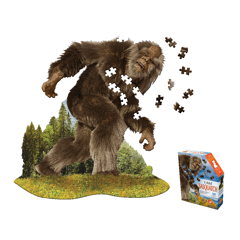 Madd Capp I AM SASQUATCH 300-piece jigsaw puzzle showing a large furry brown sasquatch figure in a forest landscape with puzzle pieces scattered, displayed with