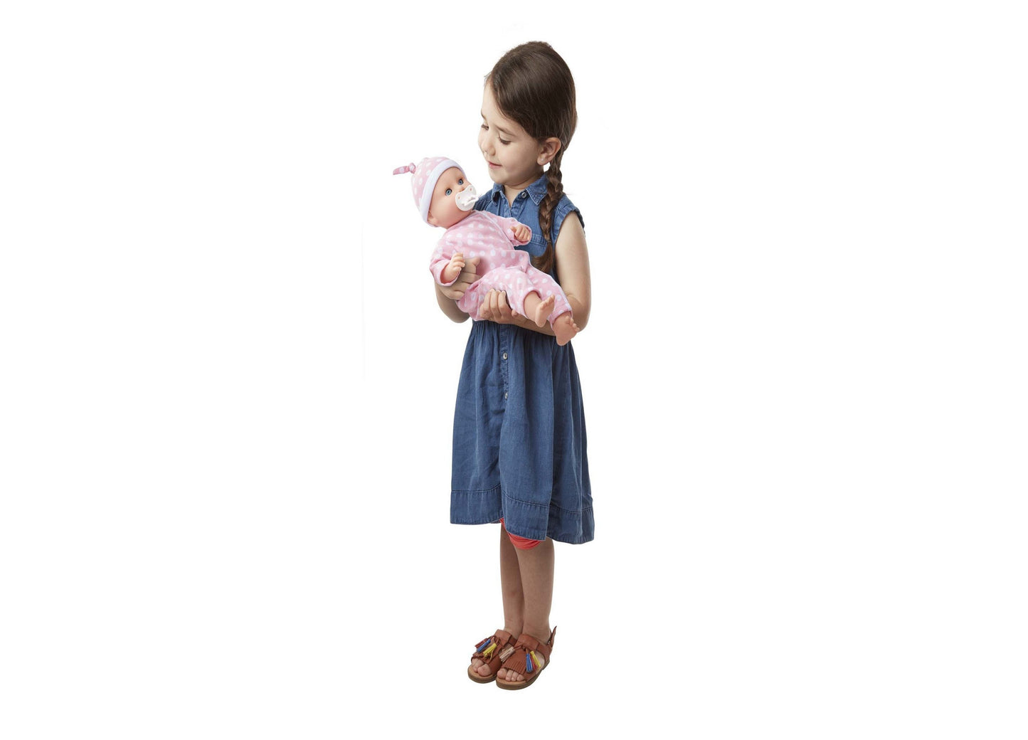 Girl holding Melissa & Doug Mine to Love Luke baby doll in pink outfit