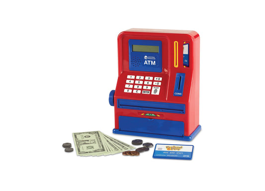 Red and blue Learning Resources ATM bank toy with number keypad, display screen, card slot, and coin dispenser, shown with play money, coins, and ATM card