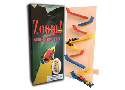 Zoom! Wooden Gravity Toy with wooden track pieces in red, blue, and yellow, and small colorful cars at bottom. Package shown on left with warning label.