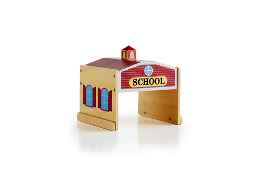 Wooden school building toy with natural plywood construction, red roof with cupola, blue cross window, red plaid signage reading SCHOOL, and blue-framed windows