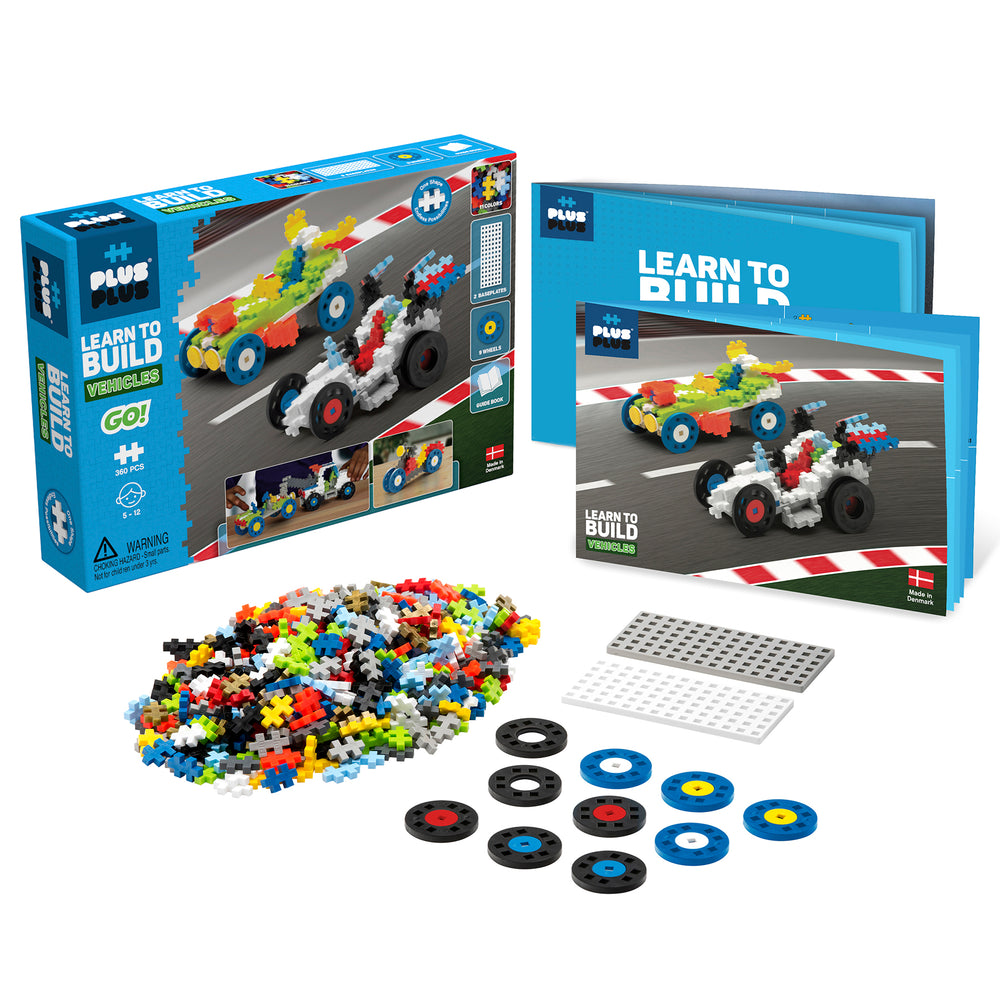 Plus-Plus Learn to Build Vehicles set with instruction booklet, 360 colorful plastic building pieces, baseplate templates, and colored wheel pieces displayed wi
