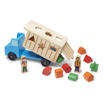 Dump Truck toy with blue cab, beige dump bed, two worker figures, and colorful geometric shapes