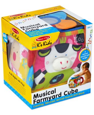 Melissa & Doug Musical Farmyard Cube with colorful fabric sides featuring farm animal faces and interactive elements in packaging
