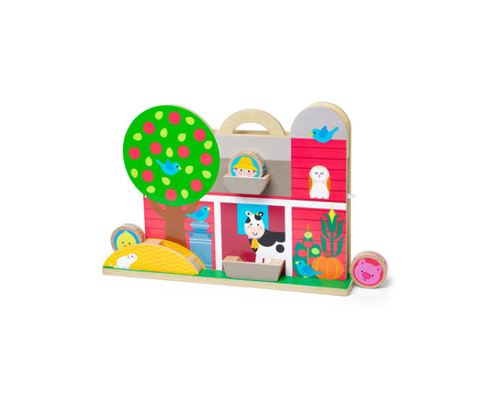 Wooden farm play set with colorful building blocks featuring a barn, tree with fruit, cow, and animal character pieces on a green base