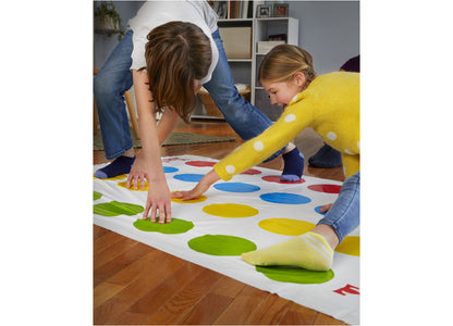 Twister Game Classic with colorful red, blue, yellow, and green spots on mat, children playing with hands and feet on...