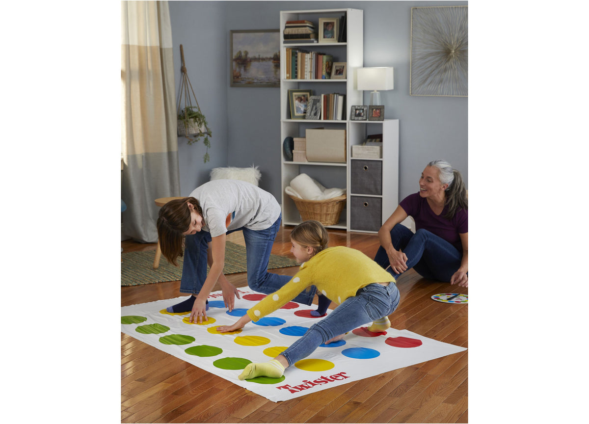 Twister Game Classic with colorful red, yellow, blue, and green spots on mat, family playing together indoors