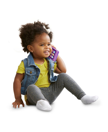 VTech Chat & Count Emoji Phone in violet held by smiling child wearing yellow shirt and denim vest