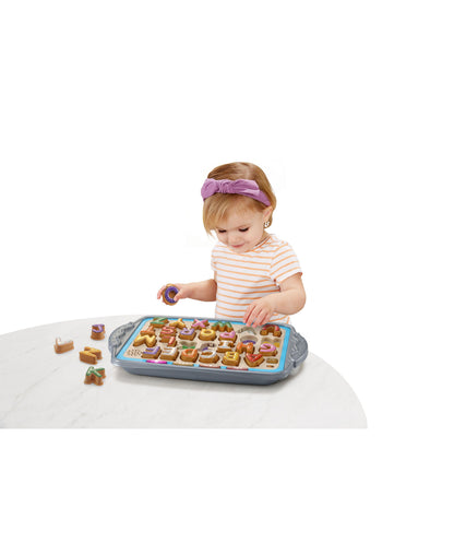 VTech Match and Learn Cookie Delights toy with toddler placing letter cookies on interactive baking tray
