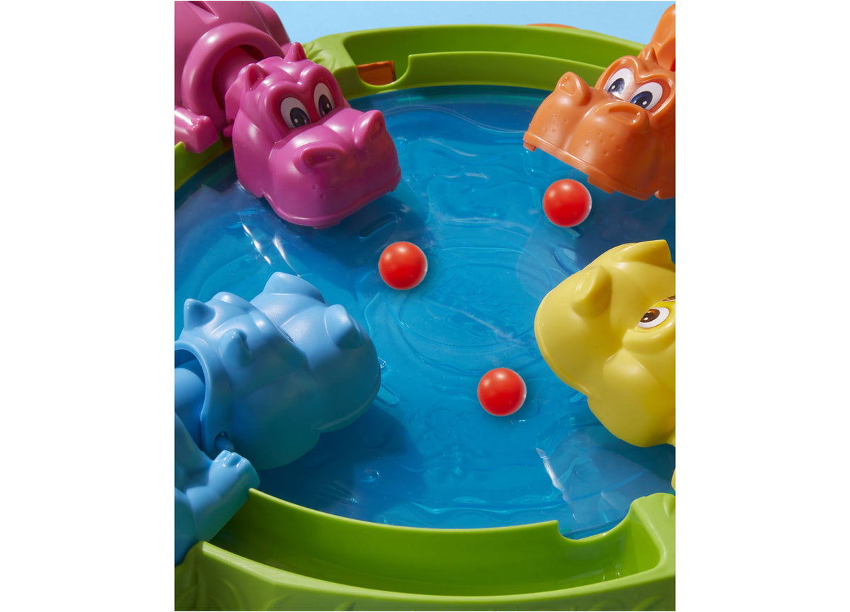 Hungry Hungry Hippos game board with four colorful hippos and red marbles in blue water arena
