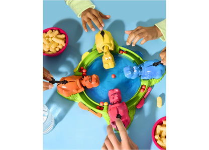 Hasbro Hungry Hungry Hippos game with four colorful hippos around blue board, players' hands reaching to control hipp...