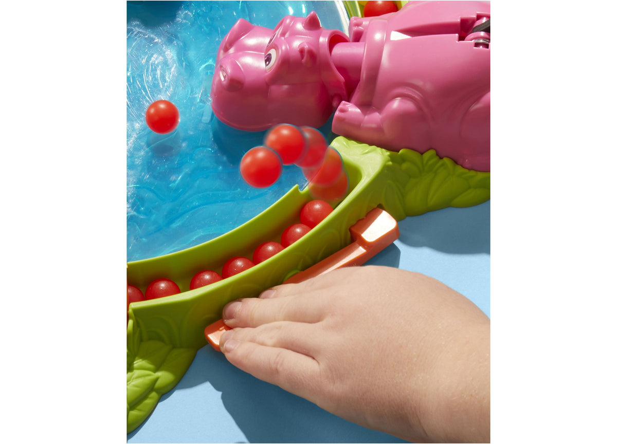 Hungry Hungry Hippos game with pink hippo, lime-green lever, and red marbles in blue water