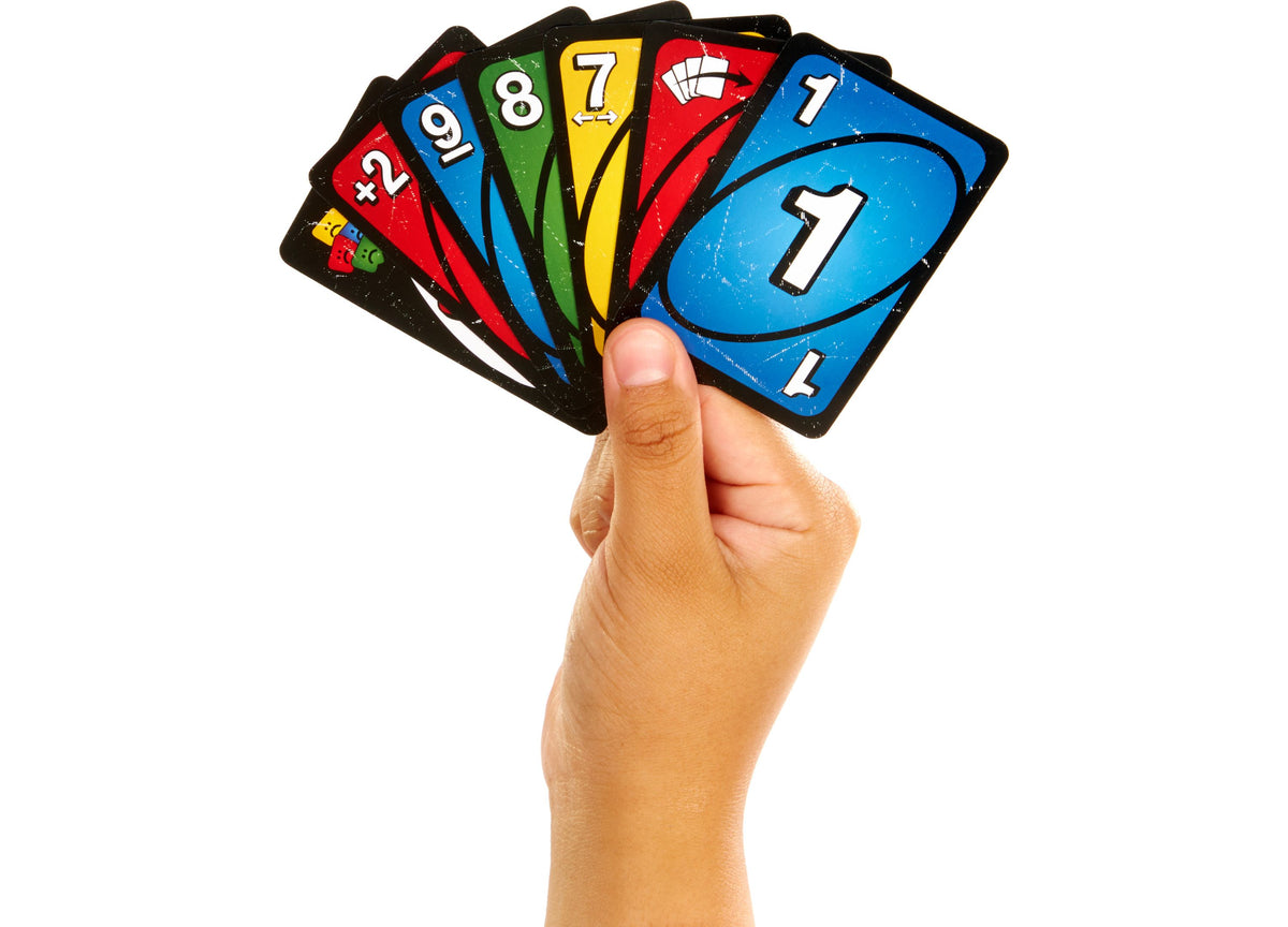 Hand holding a fan of colorful UNO Show 'Em No Mercy card game cards displaying numbers and colored sections in blue,...