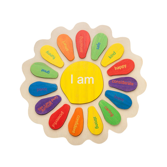 Wooden flower-shaped puzzle with yellow center reading "I am" surrounded by colorful petal pieces labeled with emotions and character traits like amazing, happy