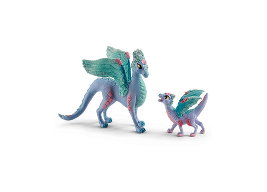 Two lavender and teal dragon figurines with turquoise wings and pink accents—a larger mother dragon and smaller baby dragon on plain background