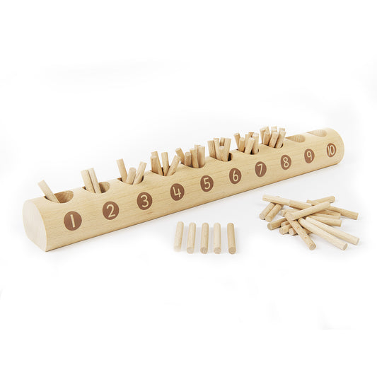 Natural wooden counting log with numbered slots 1-10 containing wooden pegs, shown with loose pegs and a small pile of extra pegs on plain background