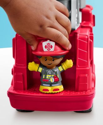 Red fire engine playset with firefighter character figure and child's hand placing it inside