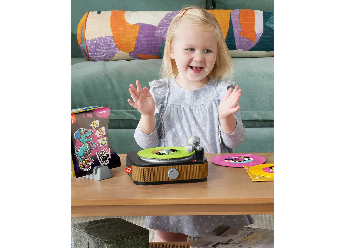 Fisher-Price Rockin' Record Player with colorful green and pink records, shown with child playing